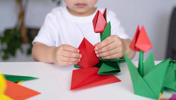 カラフルな折り紙でチューリップを折る幼児 カラフルな折り紙でチューリップを折る幼児の写真