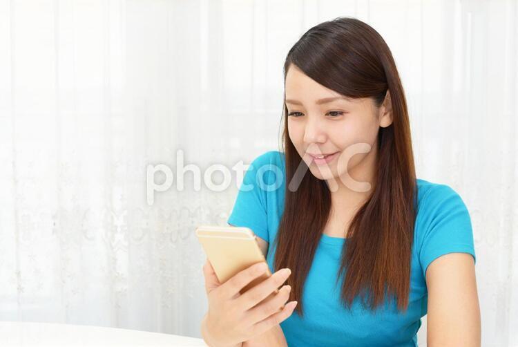 スマートフォンを持つ笑顔の女性 女性,スマートフォン,女の写真素材