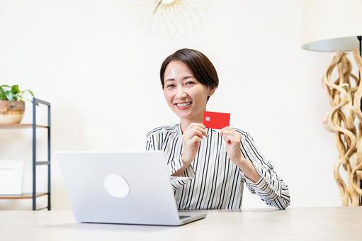 クレジットカードを持つ女性 クレジットカードを持つ女性 オンラインショッピング,クレジットカード,決済の写真素材