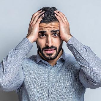 頭を抱えて困惑するの男性 頭を抱えて困惑するの男性の写真