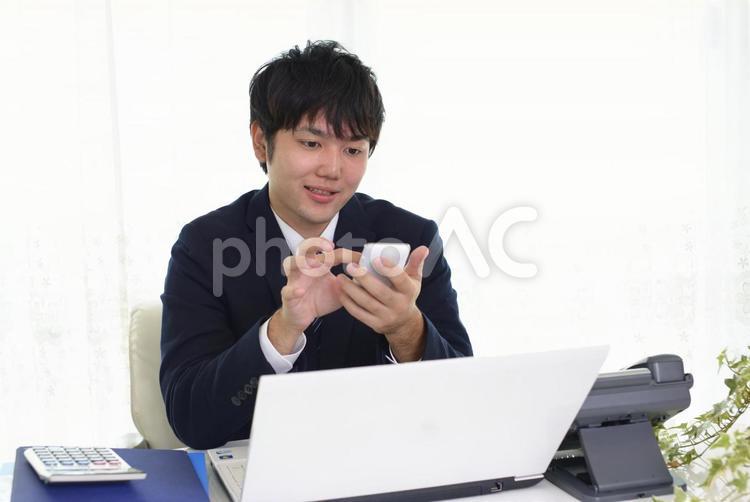 スマートフォンを持つビジネスマン 男性,スマホ,ビジネスマンの写真素材