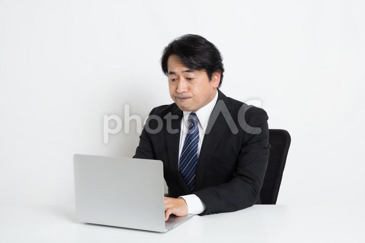 パソコンを見ながら仕事をしている中年のサラリーマン男性 中年,上司,会社員の写真素材