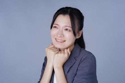 上目遣いのスーツを着た女性 女性,笑顔,嬉しいの写真素材