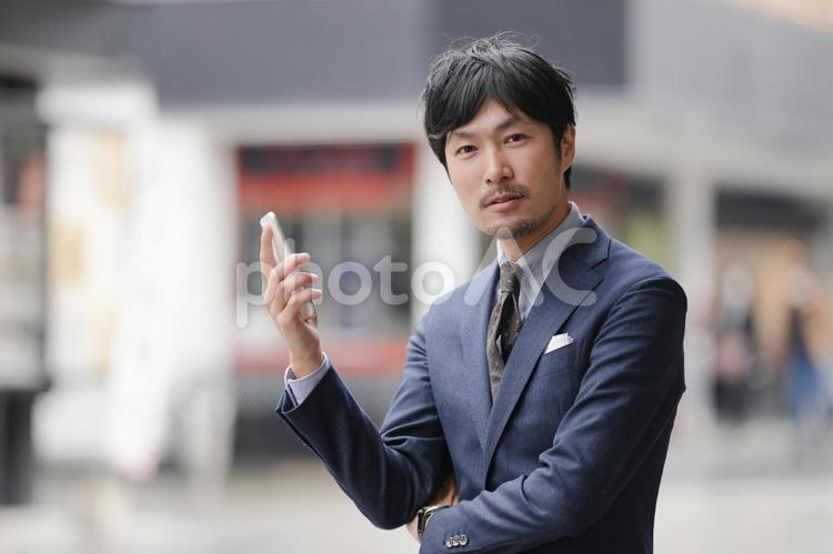 街中でスマホとビジネスマン ビジネス,スマホ,スマートフォンの写真素材