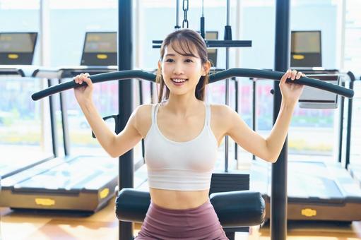 ジムでトレーニングする笑顔の女性 女性,筋トレ,スポーツジムの写真素材