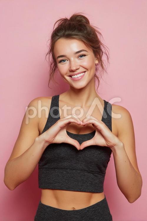 ハートサインを見せる笑顔の女性 女性,女の子,フィットネスの写真素材