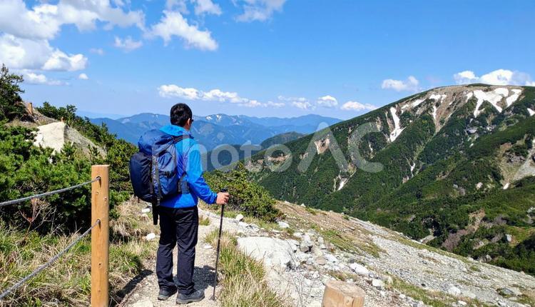 晴れた山に登山をする男性の後ろ姿 ハイキング,山,男性の写真素材