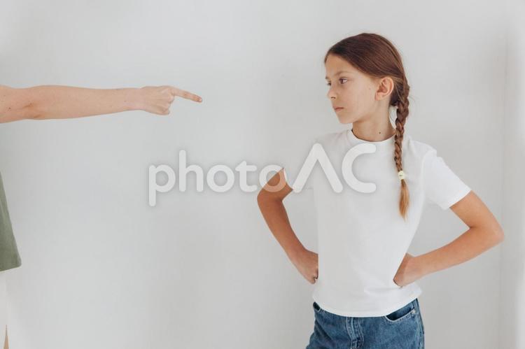 指さす人の手元と腰に手を当てる女の子 親子,女の子,手元の写真素材
