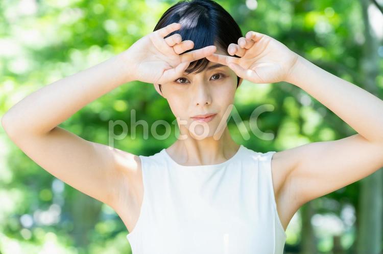 緑の中でスキンケアをする若い女性 スキンケア,ビューティー,女性の写真素材