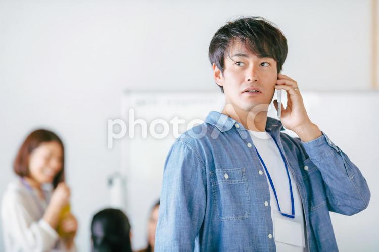スマホを持つカジュアルな服装のビジネスマン スマートフォン,スマホ,システムエンジニアの写真素材