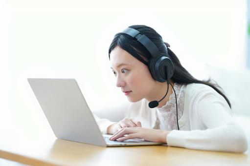 驚いた顔でパソコンを見つめるヘッドセットの女性 女性,ノートパソコン,驚くの写真素材