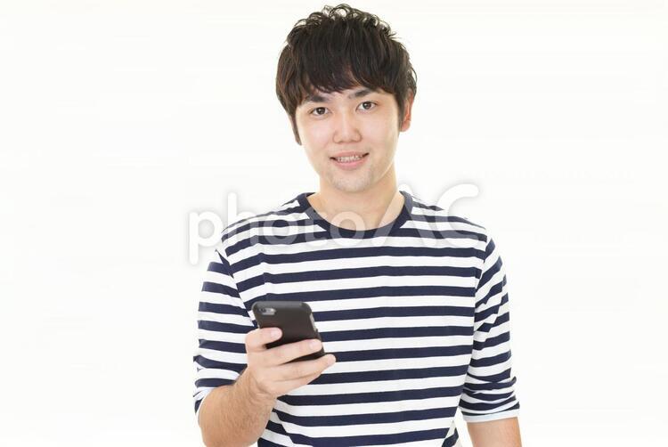 スマートフォンを持つ笑顔の男性 男性,男,スマートフォンの写真素材