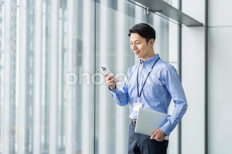 オフィスでスマホを使うエンジニア スマホ,エンジニア,ビジネスマンの写真素材