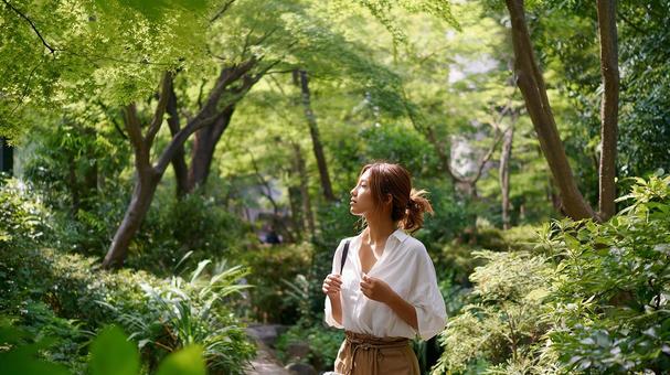 木漏れ日の中でリラックスする女性 木漏れ日の中でリラックスする女性の写真
