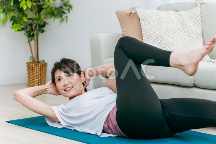 部屋でヨガをするミドル世代の女性 腹筋,筋トレ,クランチの写真素材