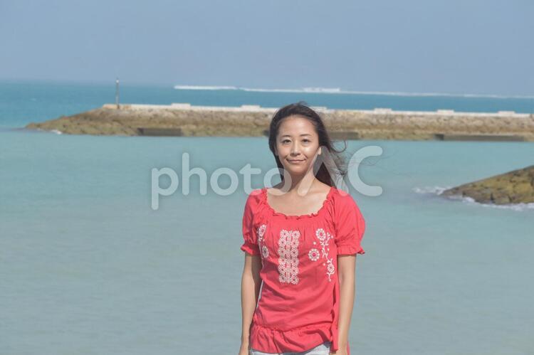 沖縄の海の背景を前にした女性 沖縄,女性,海の写真素材