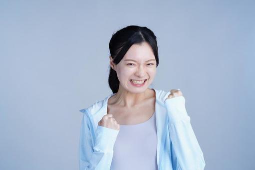 水色の服の女性がガッツポーズの写真