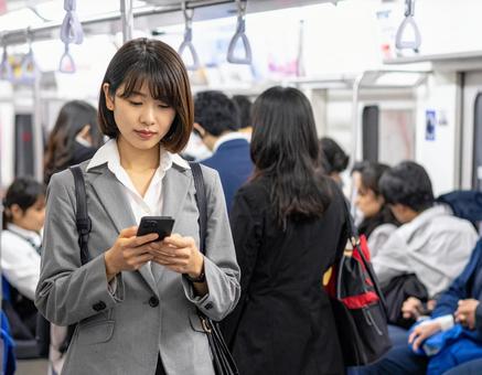 通勤電車、みんなスマホを見ているの写真