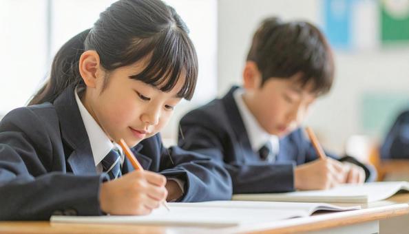 学校の教室で勉強している小学生2人 の写真