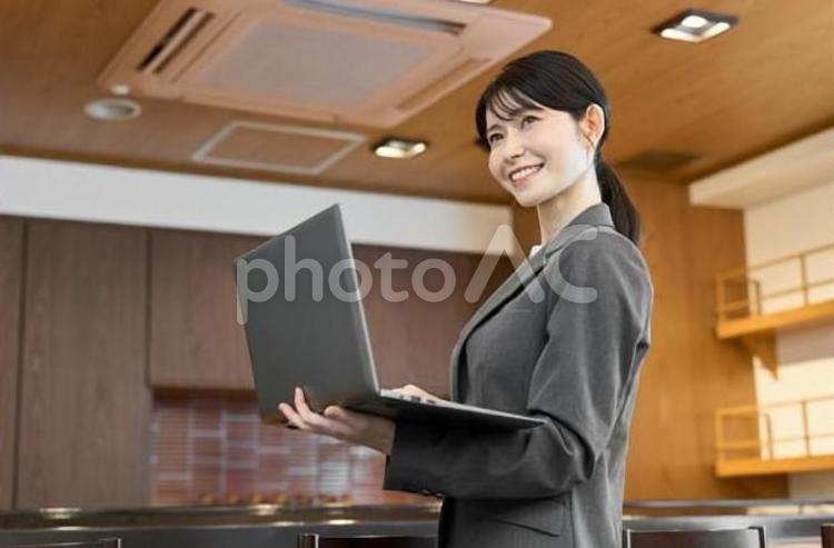 飲食店でパソコンを見るスーツを着た女性 飲食店,女性,ノートパソコンの写真素材