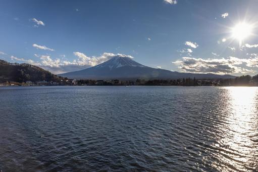 雪化粧の富士山と河口湖に映る太陽 雪化粧の富士山と河口湖に映る太陽の写真