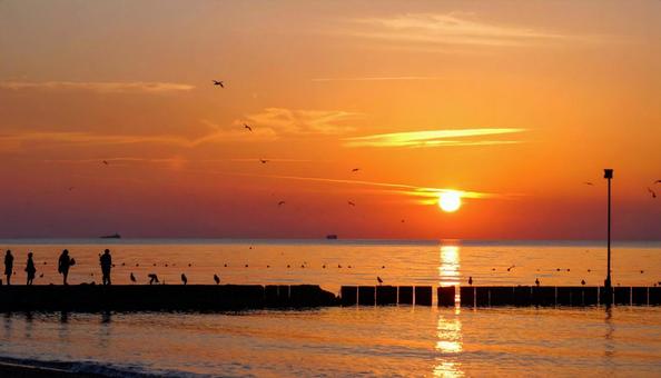 静かな海に沈む夕日の写真
