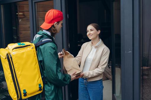 紙袋を届けに来た配達員 配達,フードデリバリー,デリバリーの写真素材