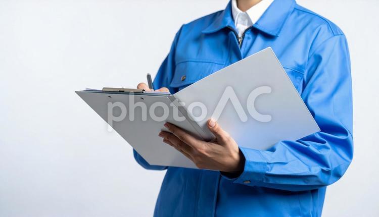 字を書く作業服の男 作業員,点検,書類の写真素材