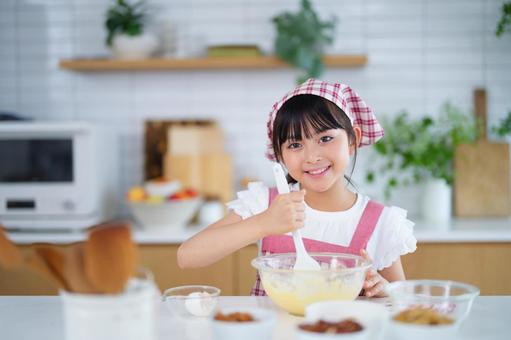 ボウルを手にピンクのエプロンを着た少女 女の子,小学生,日本人の写真素材