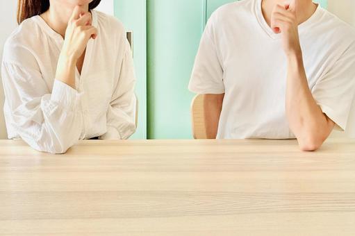 顎に手を当てて一緒に考える若い夫婦 顎に手を当てて一緒に考える若い夫婦 悩む,相談,疑問の写真素材