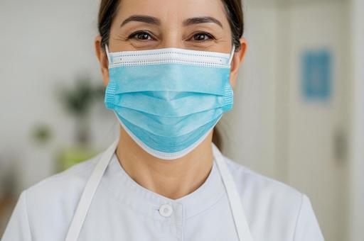 マスク越しに優しくほほ笑む女性介護士の写真