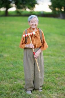 両手でスティックを待ちカメラ目線の高齢女性 女性,スティック,持つの写真素材