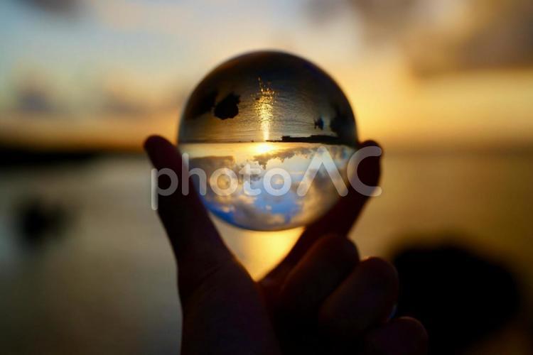 水晶玉越しに見る美しい朝日 エメラルドブルー,海,宮古島の写真素材