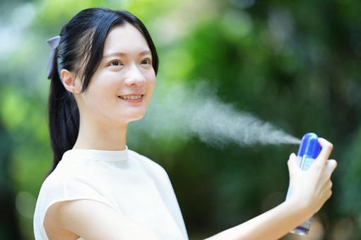 女性がスプレーを手にして笑顔を見せる 女性,笑顔,スプレーの写真素材