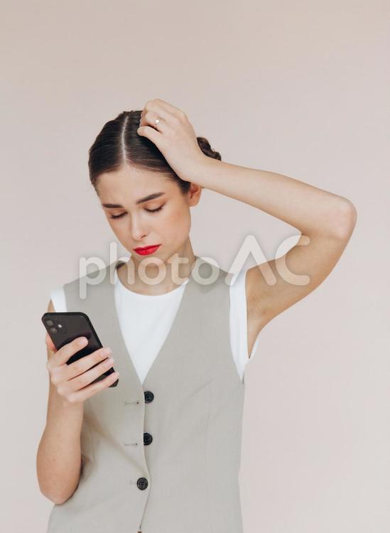 目を瞑って考える女性 女性,スタジオ撮影,携帯の写真素材