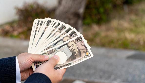 たくさんの一万円札を持つビジネスマン たくさんの一万円札を持つビジネスマンの写真