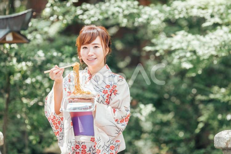 夏祭りで焼きそばを食べる浴衣姿の女性 焼きそば,縁日,夏祭りの写真素材