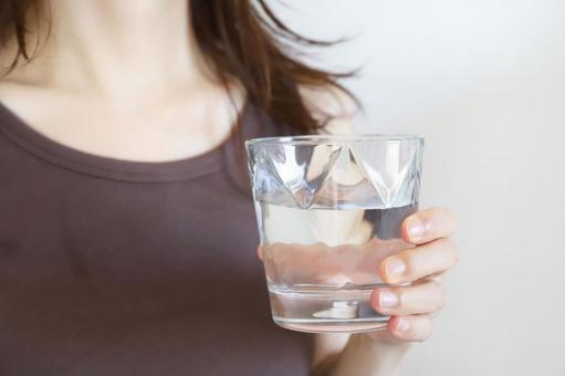 水が入ったコップを持つ女性 水が入ったコップを持つ女性 水,コップ,健康の写真素材
