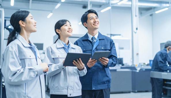 工場でタブレットで製品を検査する作業員 工場でタブレットで製品を検査する作業員の写真