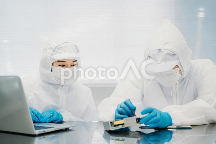 クリーンルームで精密機器を扱う女性 工場,クリーンルーム,製造業の写真素材