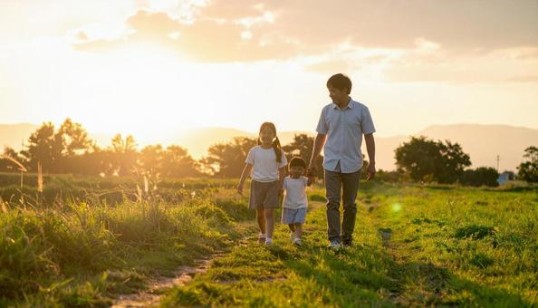 手をつないで歩く親子の写真