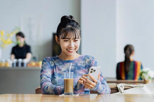 カフェでスマホを見る若い女性 カフェでスマホを見る若い女性 カフェ,スマホ,女性の写真素材