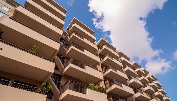 マンションを見上げる 青空背景 マンションを見上げる 青空背景の写真