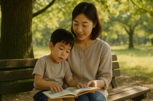 公園で絵本を読む親子 公園で絵本を読む親子の写真
