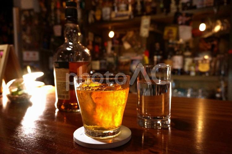 ショットバーのカウンターで飲むウイスキー ウイスキー,水割り,ロックの写真素材