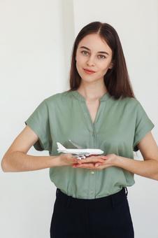 飛行機の模型を持つ女性スタッフ 事務職,接客業,アドバイザーの写真素材