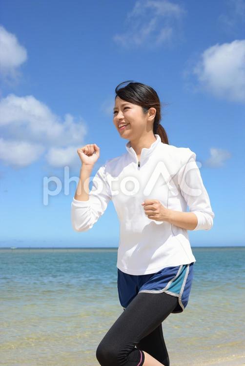 海辺でジョギングをする女性 女性,運動,健康の写真素材