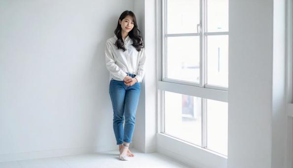 窓際に立つ女性 窓際に立つ女性の写真