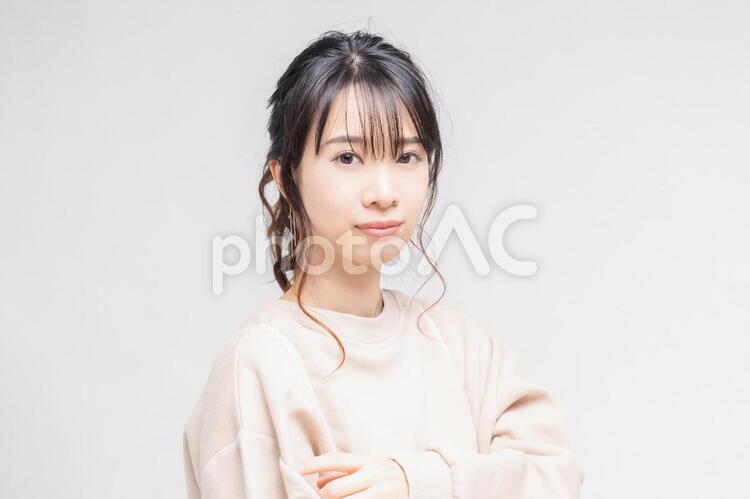 白い背景の前に立ってポーズをとる若い女性 女性,白背景,立つの写真素材
