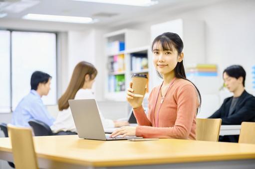 コーヒーを飲みデスクワークする女性社員 ビジネスウーマン,笑顔,デスクワークの写真素材